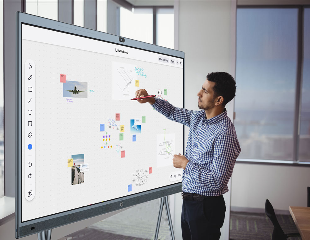 An employee uses an interactive white board during a video conference session.