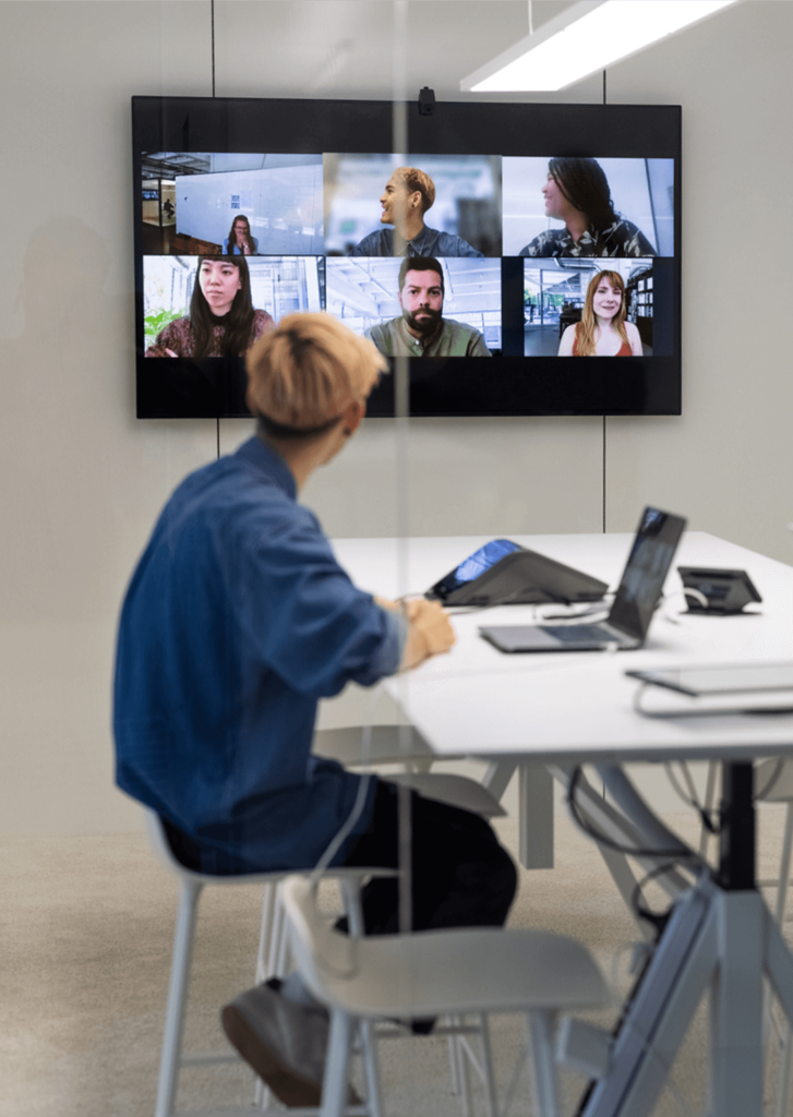 One employee interacting with a team using a modern video conference room.